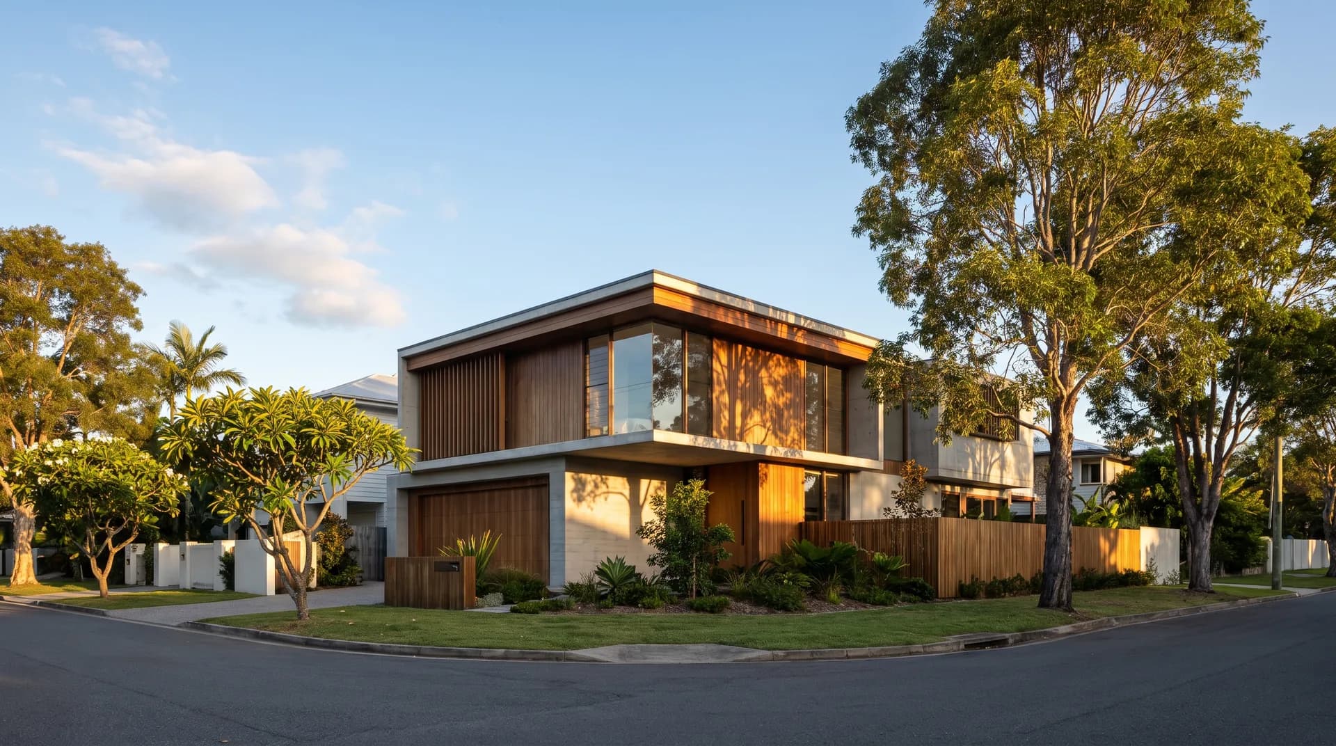 An established North Brisbane streetscape with a new family home in warm afternoon light